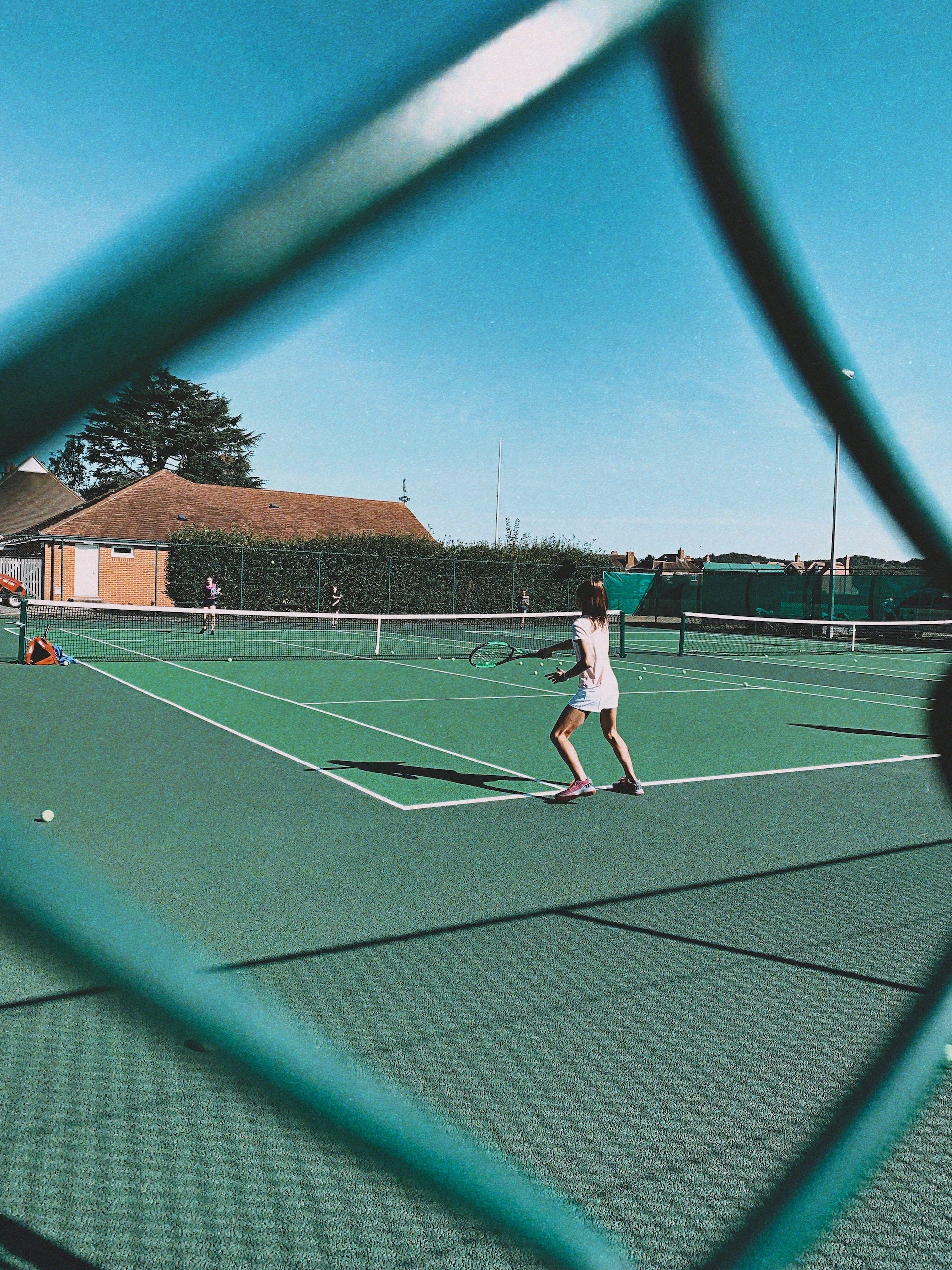 Women play tennis in a public facility.