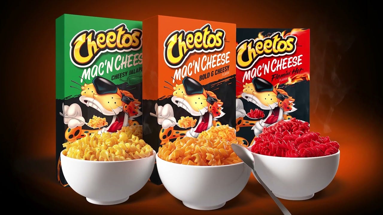 Three bowls of Cheetos mac and cheese in front of their respective boxes: Cheesy Jalapeno, Bold & Cheesy, and Flamin' Hot.