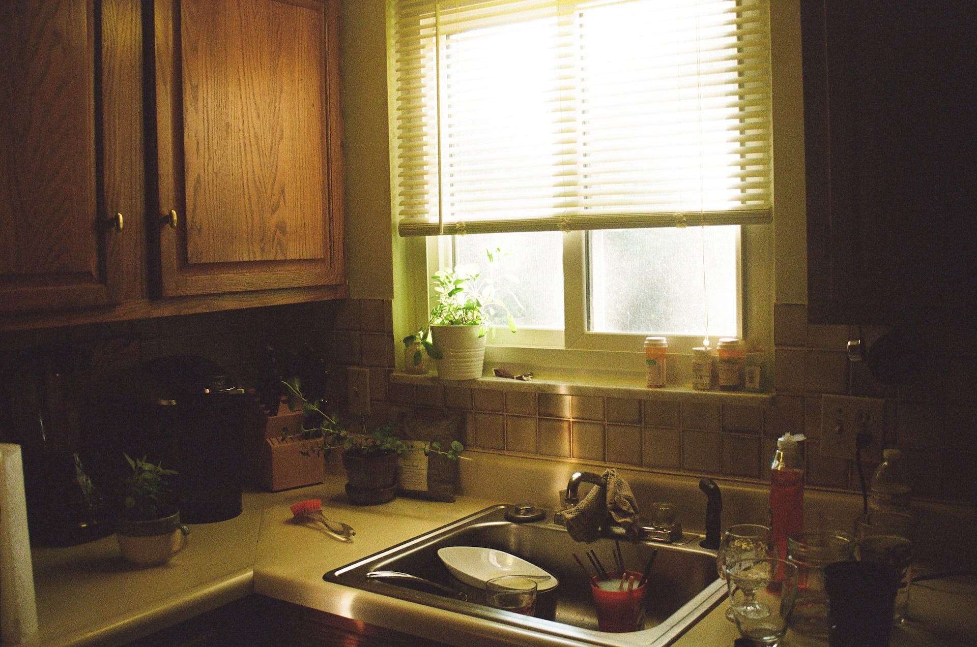 An unkempt kitchen in the afternoon.