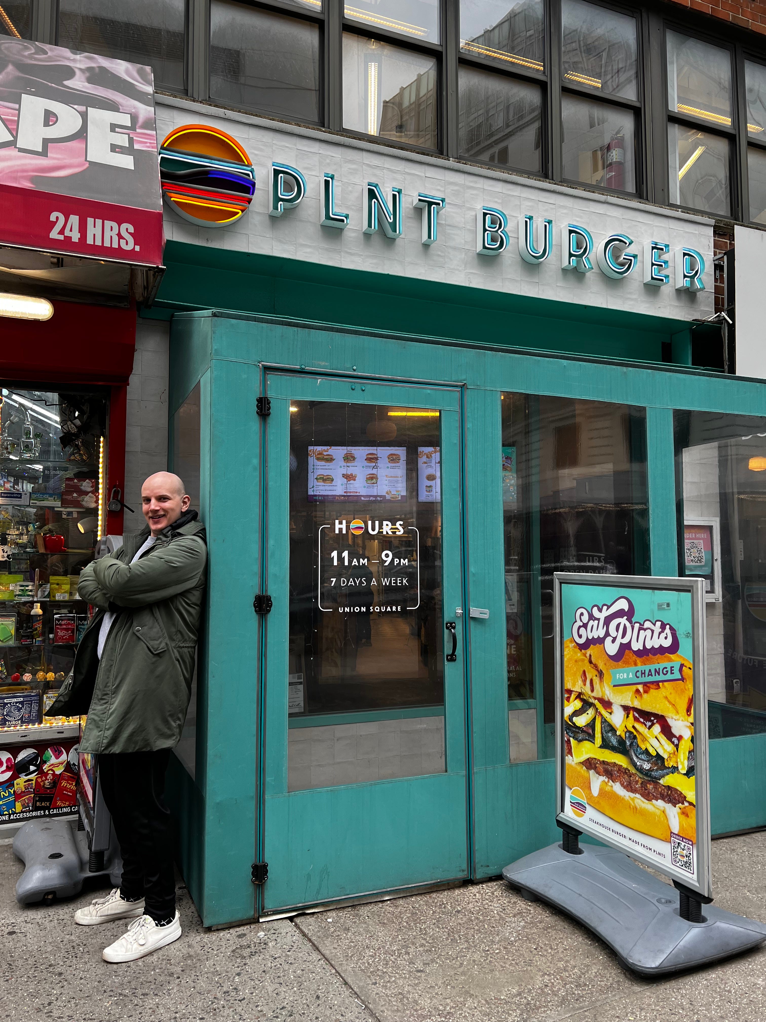 Thomas standing in front of PLNT Burger.