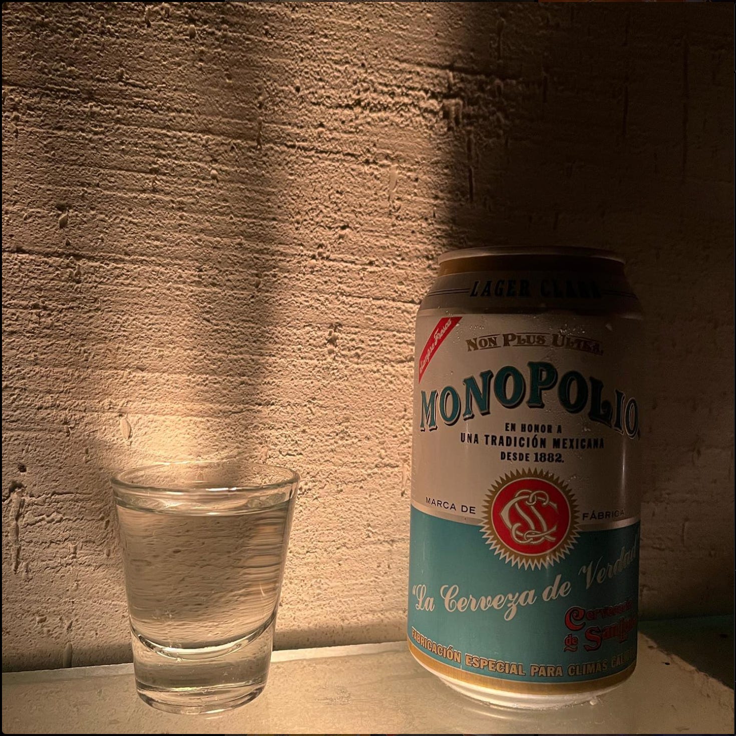 A shot of mezcal and a can of Monopolio.