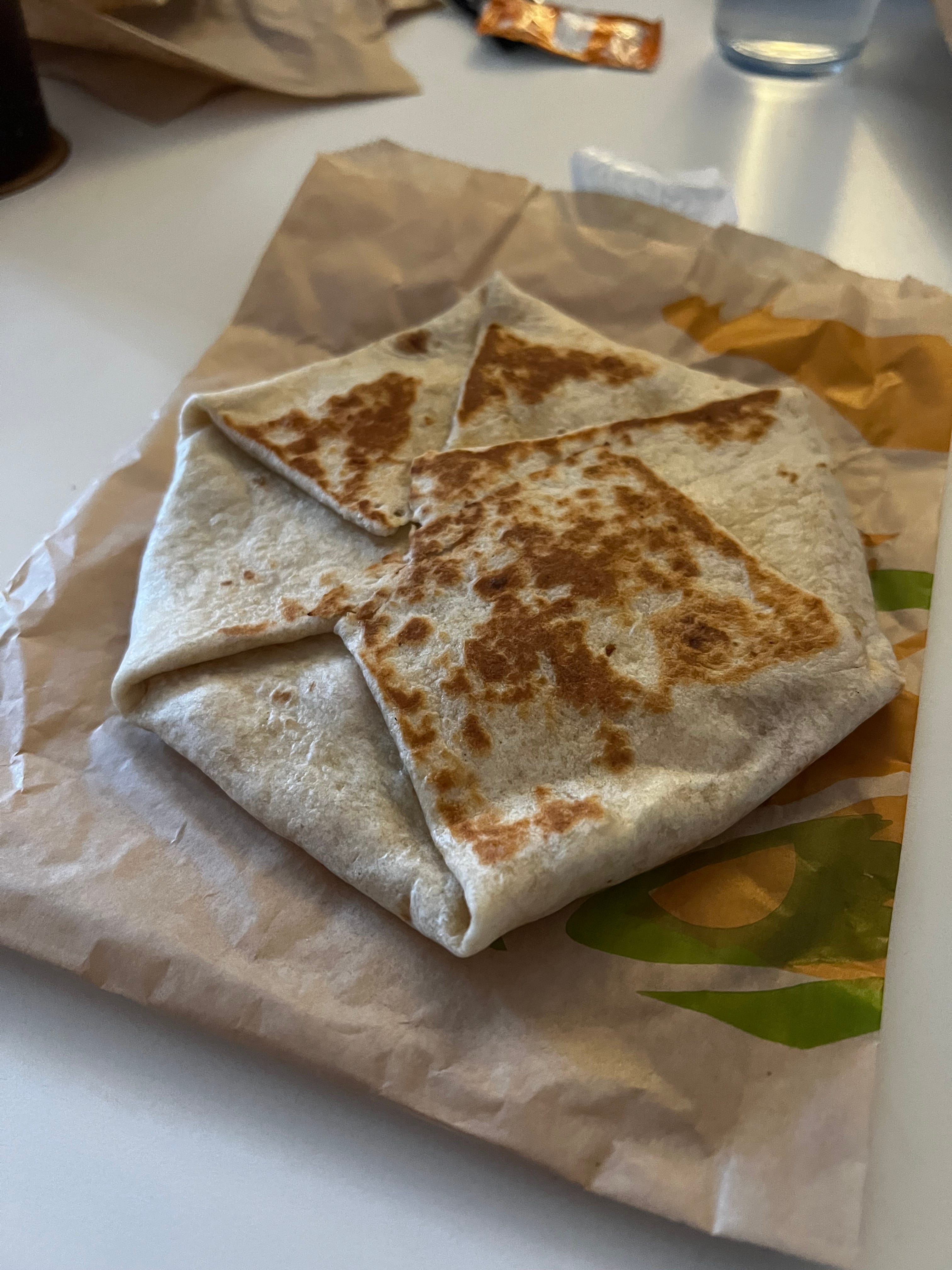 A vegan Crunchwrap Supreme sitting on a Taco Bell wrapper.