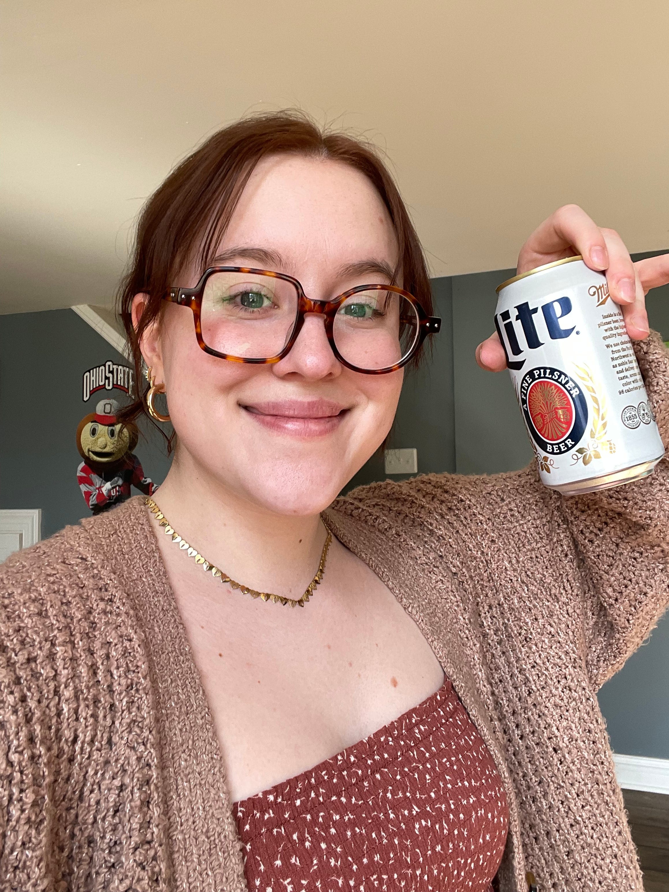 Woman holding up a can of Miller High Life.