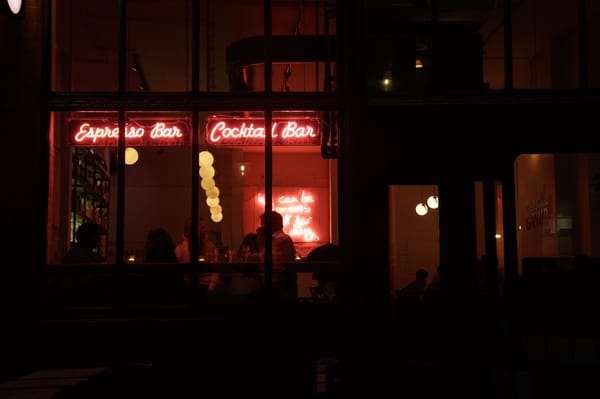 Outside of a cocktail bar at night.