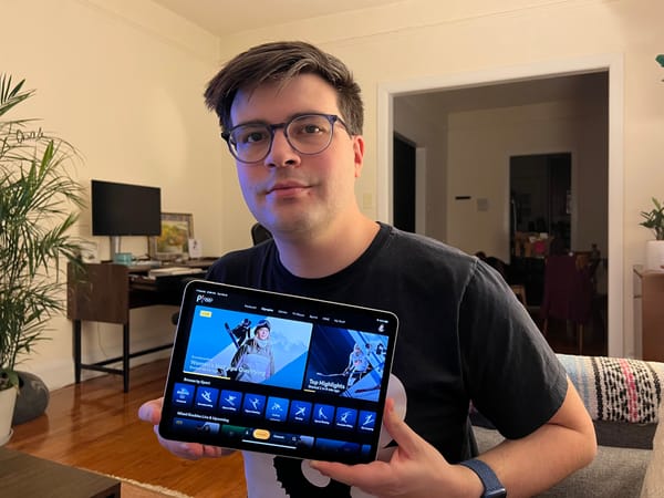 Man holds iPad open to Peacock streaming app.