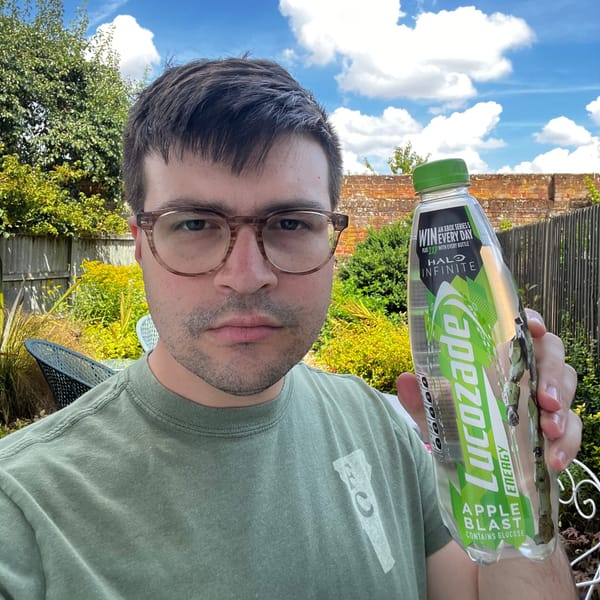 The author holds up a Lucozade Apple Blast.