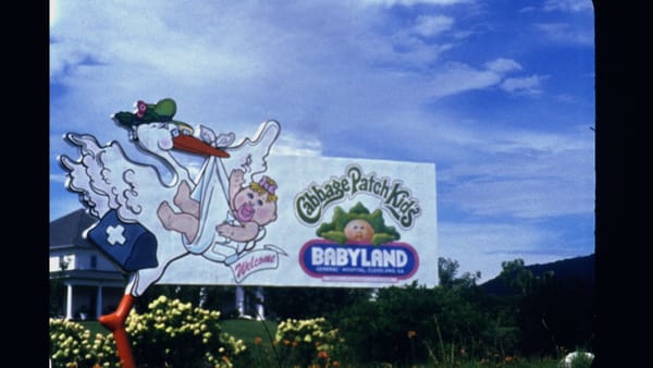 The Babyland General Hospital sign, featuring a stork delivering a waving baby.