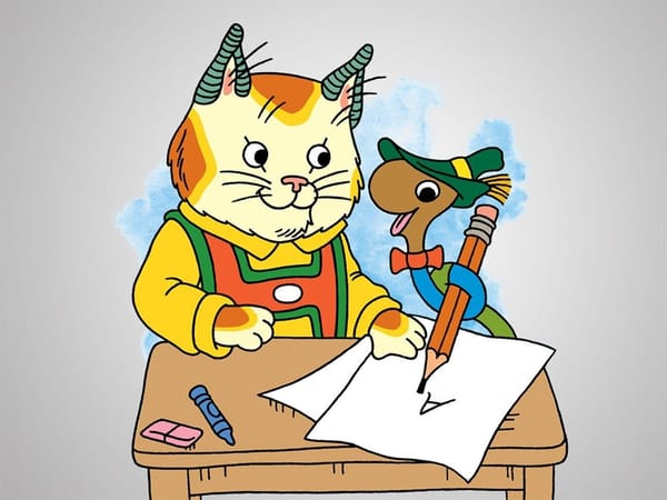 Huckle Cat, a cat wearing a shirt, and Lowly Worm, a worm wearing a bowtie and hat, sit at a desk.