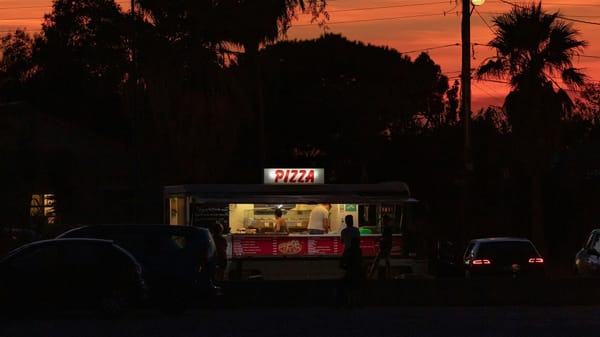 A roadside pizza joint at dusk.