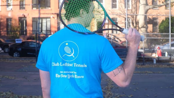 Man wearing Club Leftist Tennis t-shirt and holding a tennis racket.
